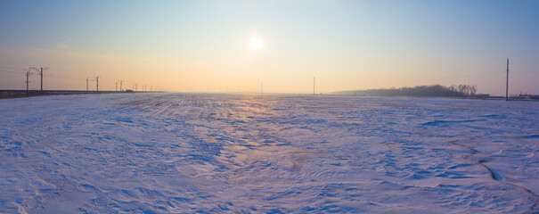 wide snowbound forest glade at the pale sunrise, winter outdoor evening scene