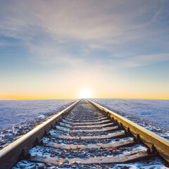 closeup railway among winter snowbound plains at the sunrise, early morning seasonal transportation scene