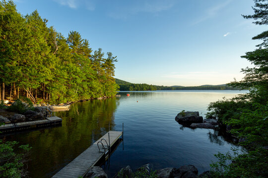 Peaceful water view out an idyllic Maine cabin on a lake with a dock. 