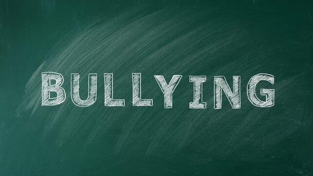BULLYING is written in chalk on a green chalkboard. Social problems of humanity. Stop school bullying