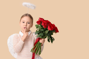 Naklejka premium Cute little girl dressed as cupid with bouquet of beautiful rose flowers showing silence gesture on beige background. Valentine's Day celebration