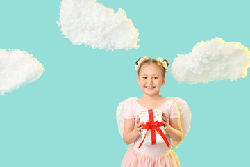 Fototapeta premium Cute little girl dressed as cupid with gift box and clouds on blue background. Valentine's Day celebration