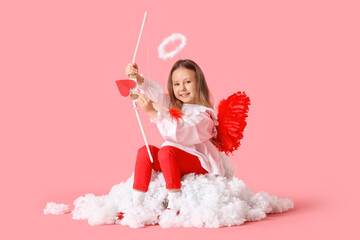 Fototapeta premium Cute little girl dressed as cupid with bow and arrow sitting on cloud against pink background. Valentine's Day celebration