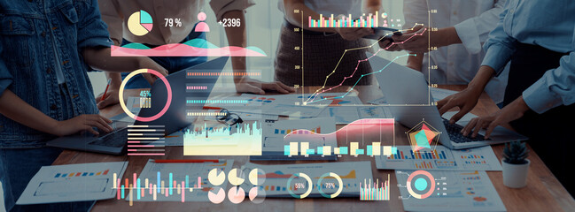 A collaborative business meeting features professionals analyzing charts and graphs on digital devices, highlighting teamwork and strategic planning efforts. Axiom