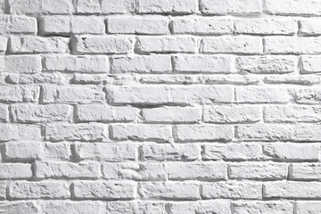 Naklejka premium white painted brick wall with textured surface and shadow details.