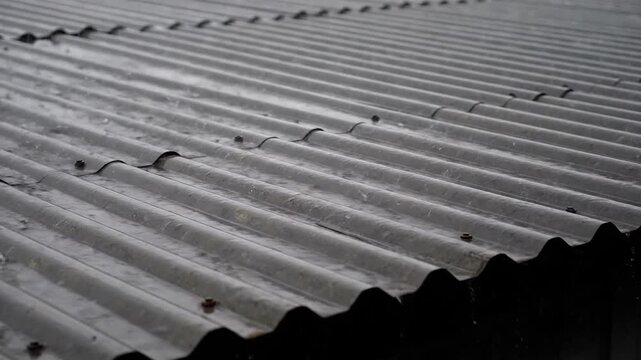 Rain falling on a corrugated metal roof, gray rainy day, weather concept, roof and water.