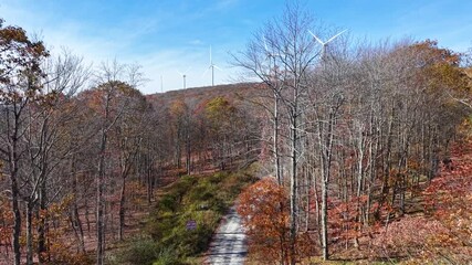 VIRGINIA - 11.10.2025 - Beautiful aerial footage raising above a Virginia forest to reveal wind power mills.