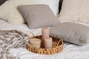 Wicker tray with candles on light bed