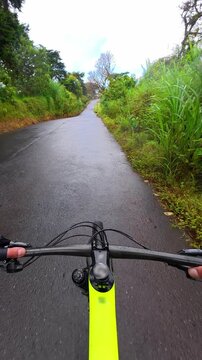 POV vertical shot of a man cycling and exercising on a road bike
