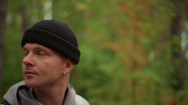 Caucasian hiker warming hands near face in pine woods, closeup profile shots showing breath and focused expression hood and beanie details, brief ritual to regain warmth, mindful pause, soft bokeh