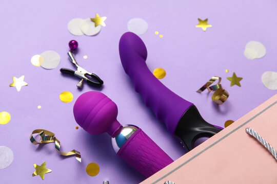 Composition with shopping bag, vibrators, nipple clamps and confetti on lilac background, closeup