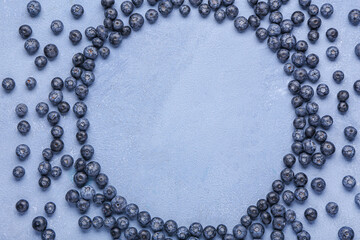 Frame made of sweet fresh blueberries on blue background