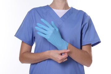 Obraz premium Medical worker putting on gloves against white background, closeup