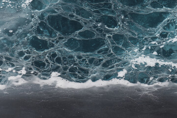Close-up view of ocean waves with intricate foam patterns and deep blue water