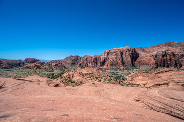 Fototapeta premium A desert landscape with a blue sky in the background. The sky is clear and the sun is shining brightly