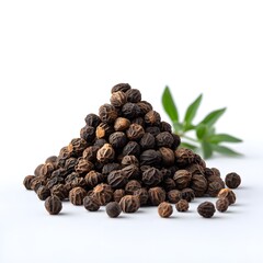 Obraz premium Heap of whole black peppercorns with a green leaf sprig in the background, isolated on a clean white surface.