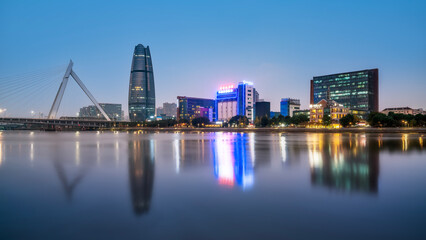 Obraz premium Night View of Modern City with Skyscrapers and Bridge
