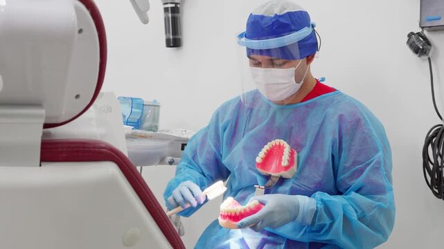 Male dentist demonstrating proper tooth brushing technique