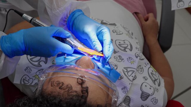 Dentist using ultraviolet light on a patient's teeth