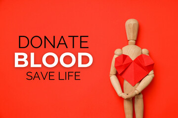 Wooden figure holds a red paper heart against a red background