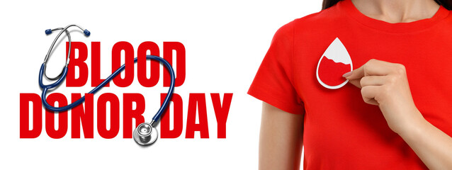 Person in red shirt applies blood drop sticker on chest