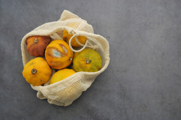 Bag of mold oranges on gray surface 