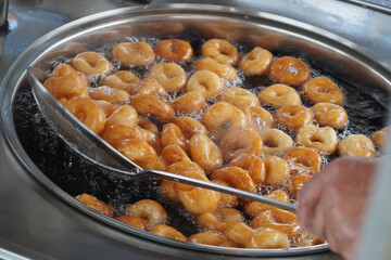 Frying fresh Turkish doughnuts in hot oil at a street stand