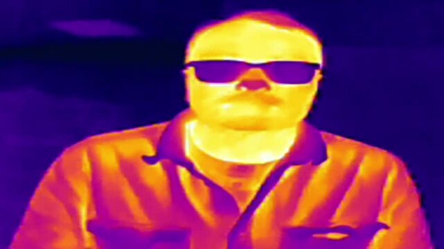 thermographic scan. Thermal imaging camera detecting elevated body temperature on a male subject n darker blue and purple tones. fusion color scheme