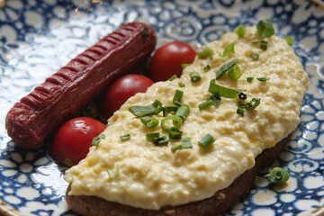 Breakfast plate with eggs and sausage on a decorative dish