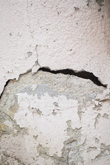 Cracked wall showing exposed surface and peeling paint