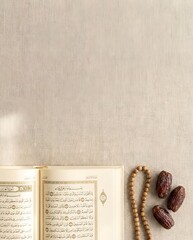 Open Holy Quran with Prayer Beads and Dates on Textured Fabric, Symbolizing Islamic Devotion