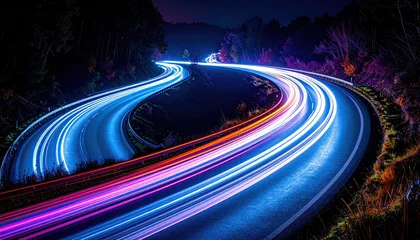 Fototapete Fahrzeug Long exposure captures light trails of vehicles weaving through a dark, curving highway at night  © Tinri