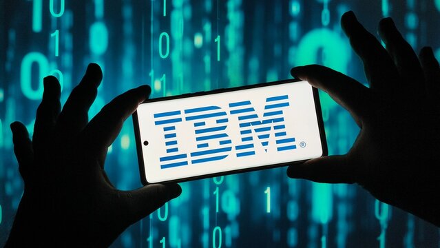 Hands holding smartphone with IBM logo on screen