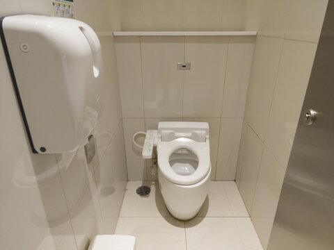 Clean Modern Bathroom Interior with Toilet and Hand Dryer Features