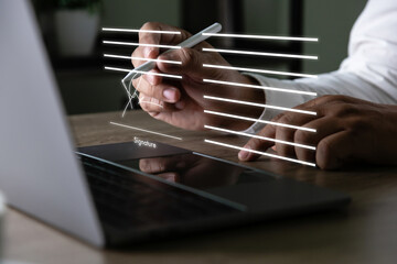 Electronic signature concept, businessman signs document on a laptop, secure e signing, document...
