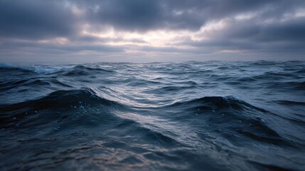 A dynamic seascape of dark choppy ocean waves under a moody overcast sky