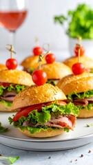 Group of savory sandwiches, garnished with cherry tomatoes and secured with golden pins. Soft focus, appealing presentation