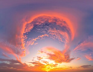 Naklejka premium A mesmerizing panorama of the sky ablaze with vivid sunset colors. A ring of clouds encircles a rich blue. The sun glows brightly below
