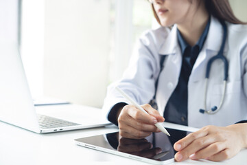 Close up of woman doctor using digital tablet at medical clinic office. Closeup of doctor have a telemedicine with patient and using stylus pen on digital tablet, prescription, patient medication