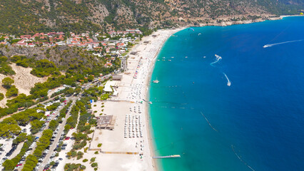 Oludeniz, Turkey. Aerial drone view of a paraglider with blue parachute flying over Oludeniz Beach and the Blue Lagoon, Babadag Mountain in the background, summer.. Aerial View © Video Render