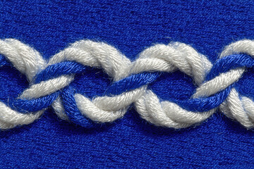 Close-up of blue and white twisted yarn on textured background