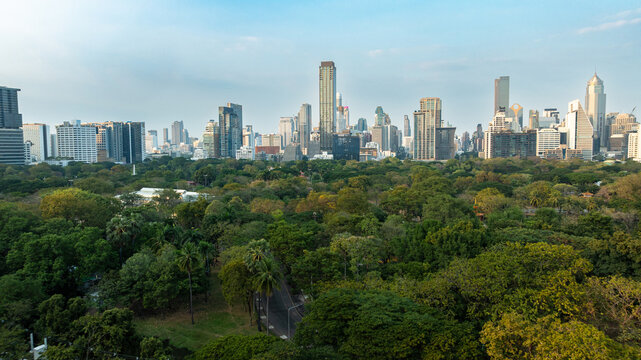 High angle view of Lumphini Park with Bangkok city skyline and skyscrapers in the background, Thailand.