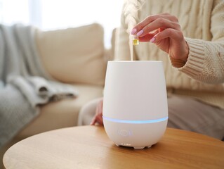 Woman Adding Essential Oils to Ultrasonic Diffuser for Aromatherapy