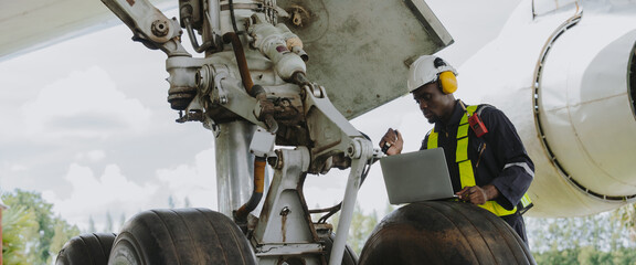 Mechanics inspect the engines of a large plane before takeoff at a summer airport.(PHOTO) © eakarat