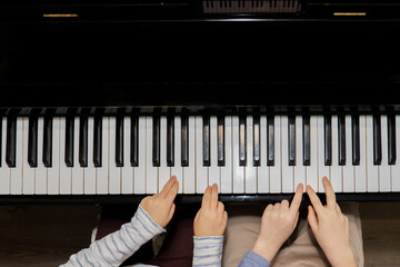 Children's hands playing piano keyboard. Early childhood music education and creativity development concept
