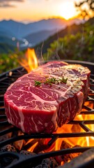 A raw steak sizzles on a grill with flames and herbs at sunset