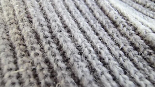 Macro shot of grey knitted wool fabric texture with detailed stitching