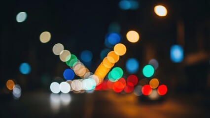 Blurry lights streak down a city street at night, creating bokeh