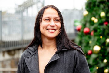 Maori woman in front of a Christmas tree in an urban area in Auckland