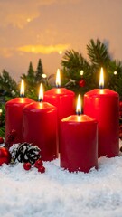 A serene winter scene with lit red candles surrounded by snow and evergreen branches